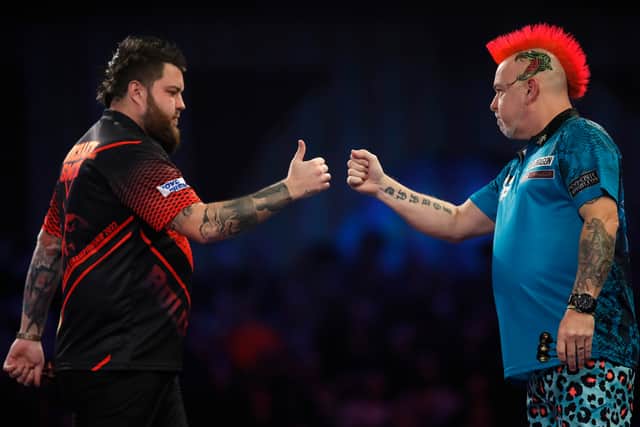  Michael Smith of England and Peter Wright of Scotland fist pump during the Finals on Day Sixteen of The William Hill World Darts Championship at Alexandra Palace on January 03, 2022 in London, England