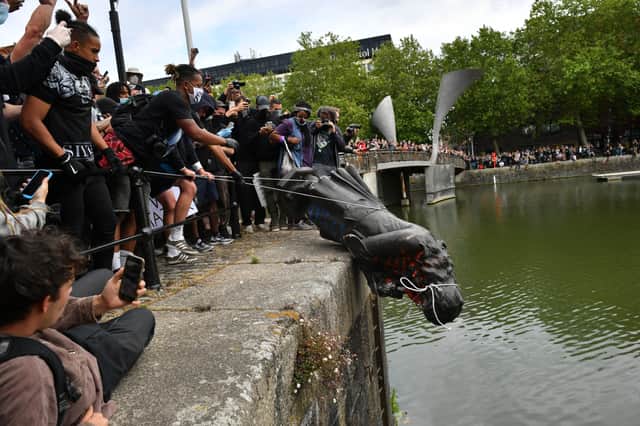 Protesters throw the statue into the harbour during a Black Lives Matter protest. (Credit: PA)