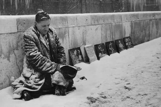 Albert Stewart, a pavement artist, on his snow covered pitch outside the National Gallery in London.  (Photo by Keystone/Getty Images)