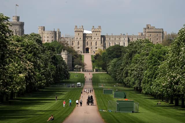 People walk along the Long Walk leading up to Windsor Castle in Windsor, west of London (Photo by Daniel LEAL / AFP) (Photo by DANIEL LEAL/AFP via Getty Images)