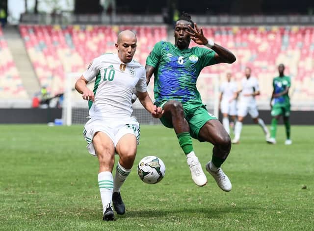Algeria’s forward Sofiane Feghouli (L) fights for the ball with Sierra Leone’s midfielder John Kamara during the Group E Africa Cup of Nations (CAN) 2021 football match between Algeria and Sierra Leone. (Photo by CHARLY TRIBALLEAU/AFP via Getty Images)