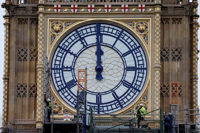 Workers remove the scaffolding from the restored west dial of the clock on Elizabeth Tower, commonly known by the name of the bell Big Ben (Photo: TOLGA AKMEN/AFP via Getty Images)