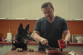 Ricky Gervais feeding dog Brandy (the dog is called Brandy, he’s not feeding brandy to the dog) (Credit: Natalie Seery/Netflix)