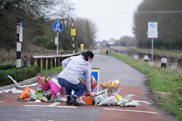 A woman lays flowers at the scene where Ashling’s body was found in Wednesday afternoon. (Credit: PA)