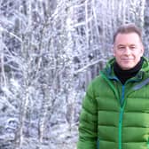 Chris Packham, wearing a green puffy coat, in a winter-y forest (Credit: BBC/Jo Charlesworth)