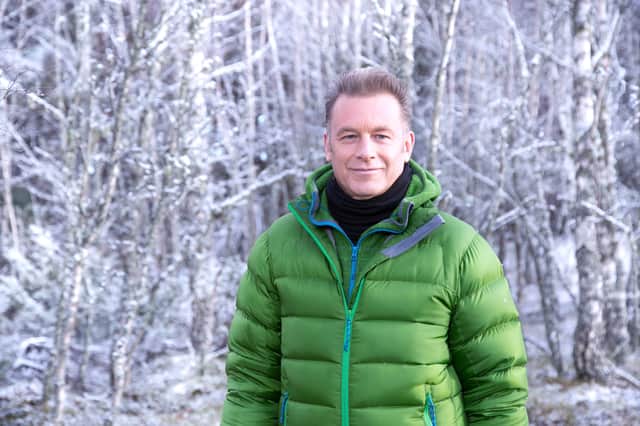 <p>Chris Packham, wearing a green puffy coat, in a winter-y forest (Credit: BBC/Jo Charlesworth)</p>