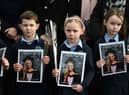 Pupils from Ashling Murphy’s class hold photographs of her and red roses ahead of her funeral at St. Brigidâs Church, County Offaly on January 18, 2022 in Tullamore, Ireland. (Picture: Getty)