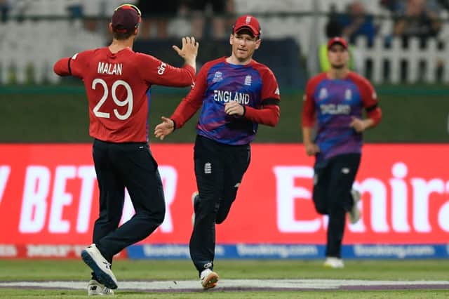 England’s captain Eoin Morgan (C) celebrates with teammates after taking a catch. (Photo by AAMIR QURESHI/AFP via Getty Images)