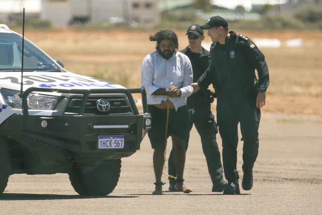 Terence Darrell Kelly boards a plane after being taken into custody by members of the Special Operations Group (Photo: Tamati Smith/Getty Images)