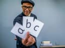 Jay Blades, holding out cards with the letters a b c on them (Credit: BBC / Hungry Bear / Ben Gregory-Ring)