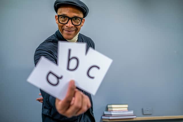 Jay Blades, holding out cards with the letters a b c on them (Credit: BBC / Hungry Bear / Ben Gregory-Ring)