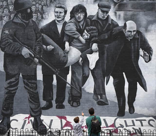 A young boy points at a mural depicting a scene from Bloody Sunday (Photo: Charles McQuillan/Getty Images)