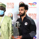 Mohamed Salah (R) poses with the man of the match trophy (Photo by DANIEL BELOUMOU OLOMO/AFP via Getty Images)
