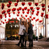 Women pose for a selfie under heart-shaped balloons (Photo: DIMITAR DILKOFF/AFP via Getty Images)