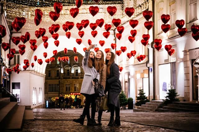 Women pose for a selfie under heart-shaped balloons (Photo: DIMITAR DILKOFF/AFP via Getty Images)