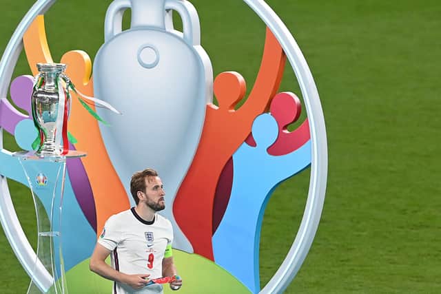 England's forward Harry Kane walks past the trophy after the UEFA EURO 2020 final football match between Italy and England at the Wembley Stadium in London on July 11, 2021