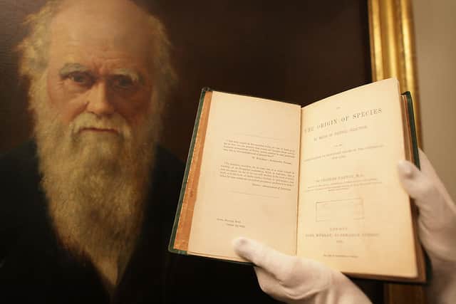 An original copy of The Origin of Species, displayed in front of a portrait of Charles Darwin (Photo: Peter Macdiarmid/Getty Images)