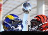 Helmets of the Los Angeles Rams and Cincinnati Bengals sit in front of the Lombardi Trophy.