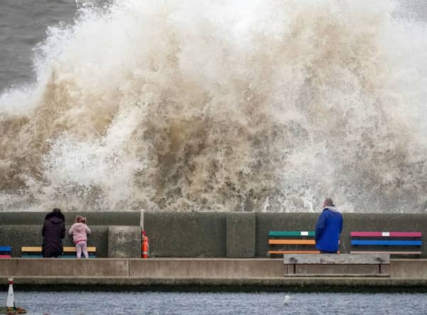 People view the waves created by high winds and spring tides hitting the sea wall at New Brighton promenade in Liverpool (Photo: Christopher Furlong/Getty Images)