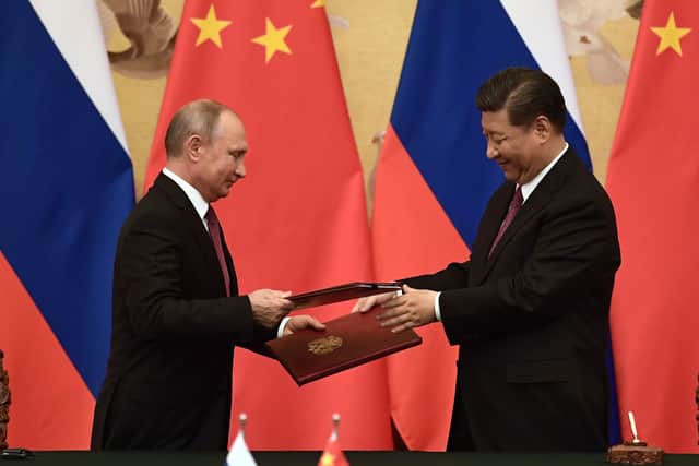 Vladimir Putin (L) and Chinese President Xi Jinping (R) exchange documents during a signing ceremony in June 2018 (Photo: NICOLAS ASFOURI/AFP via Getty Images)