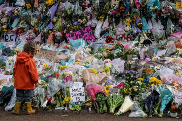 A young boy looks at floral tributes left at Clapham Common bandstand where people continued to pay their respects to Sarah Everard on March 16, 2021 (image: Getty Images)