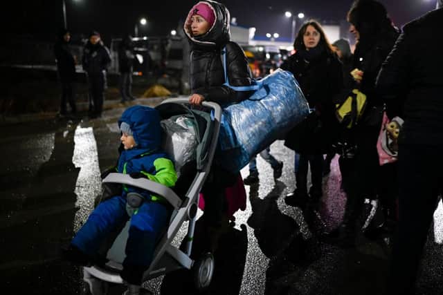 A refugee woman from Ukraine pushes a stroller with a small child after crossing the Moldova-Ukrainian border (Photo: NIKOLAY DOYCHINOV/AFP via Getty Images)