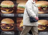 A woman passes an advertisement outside a fast food outlet in Bristol (Credit: Getty images) 