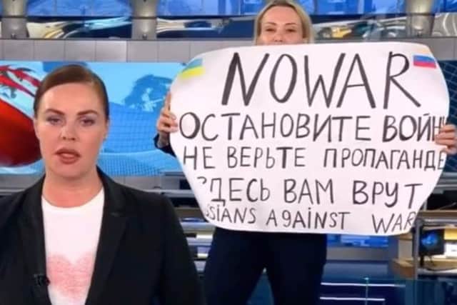A screenshot from the news report in which Marina Ovsyannikova appeared with a protest against Putin and the war in Ukraine