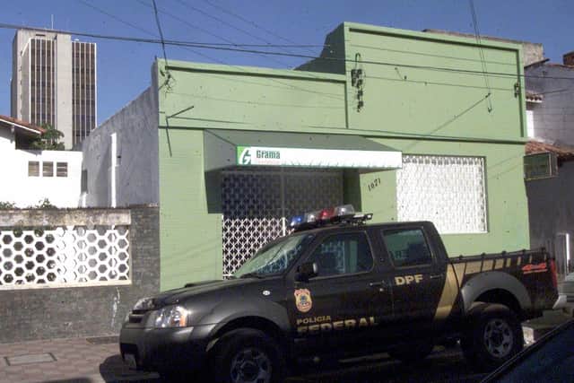 A Brazilian Federal Police car remains parked in front of the house from where the Central Bank robbers dug their tunnel