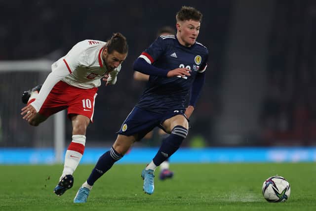 Nathan patterson of Scotland out paces Grzegorz Krychowiak of Poland during the international friendly match between Scotland and Poland at Hampden Park on March 24, 2022