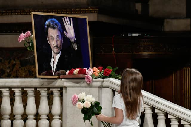 A young girl pays tribute to the late Johnny Holiday during a mass in his memory in 2018  (Photo by Philippe LOPEZ / AFP) 