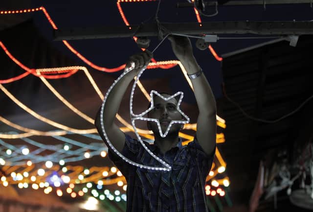 A shopkeeper in Jerusalem hangs a star and crescent - a symbol of Islam - ahead of Ramadan. (Credit: Getty Images)