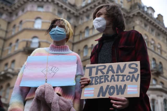Demonstrators hold placards with the transgender flag colours (Photo: Hollie Adams/Getty Images)