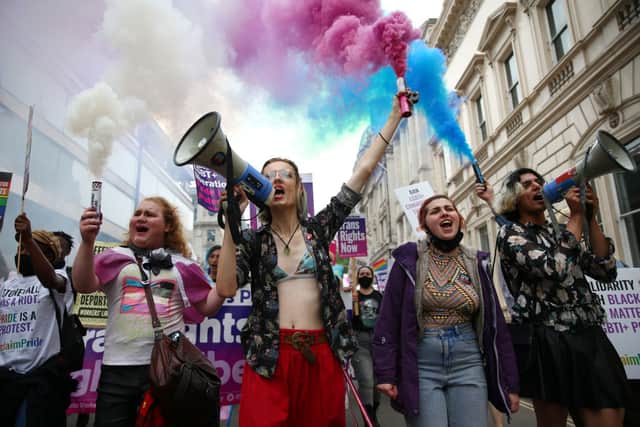 Demonstrators hold smoke flares during a Reclaim Pride March on 24 July 2021 in London (Photo: Hollie Adams/Getty Images)