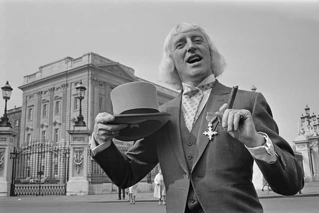 Jimmy Savile (1926 - 2011), showing off his OBE after his investiture at Buckingham Palace, London, 21st March 1972 (Photo: Leslie Lee/Daily Express/Hulton Archive/Getty Images)