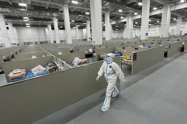 A staff member walks inside a makeshift hospital that will be used for Covid-19 coronavirus patients in Shanghai on April 7, 2022