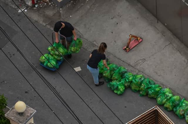 Residents take bags with vegetables at the entrance of a neighborhood during a COVID-19 lockdown in the Jing'an district in Shanghai on April 11, 2022. 
