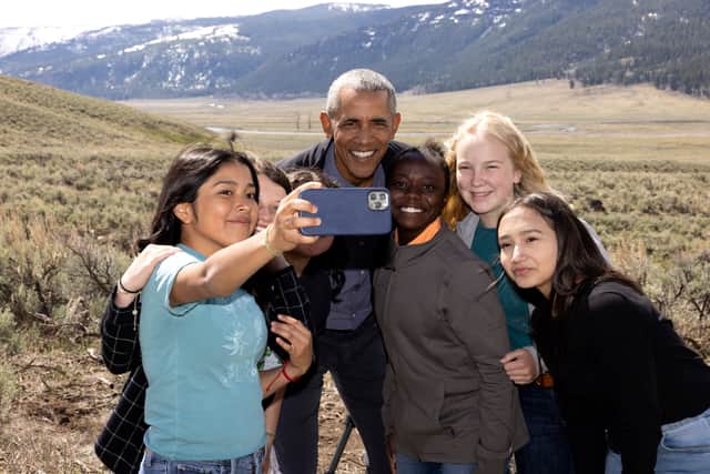 Barack Obama poses for a cell phone selfie photo with six children in front of a snow-capped mountain range in Yellowstone National Park in Wyoming in Our Great National Parks (Credit: Pete Souza/Netflix)
