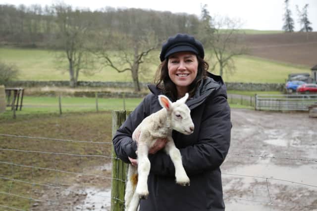 Jill Hallfpenny at Cherrytrees farm holding a lamb (Credit: BBC/Tern/Ceara East)