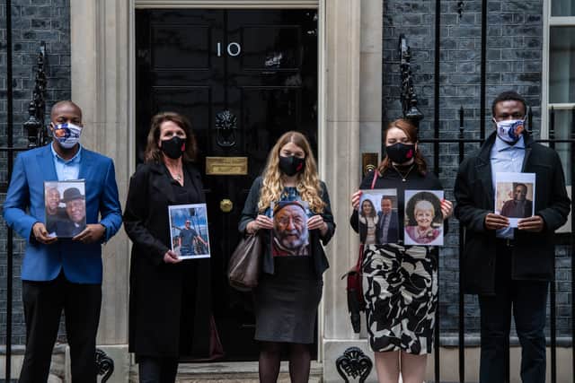 Representatives from Covid-19 Bereaved Families for Justice pose for photographs outside 10 Downing Street holding photos of their deceased relatives after meeting Boris Johnson at Downing Street on September 28, 2021