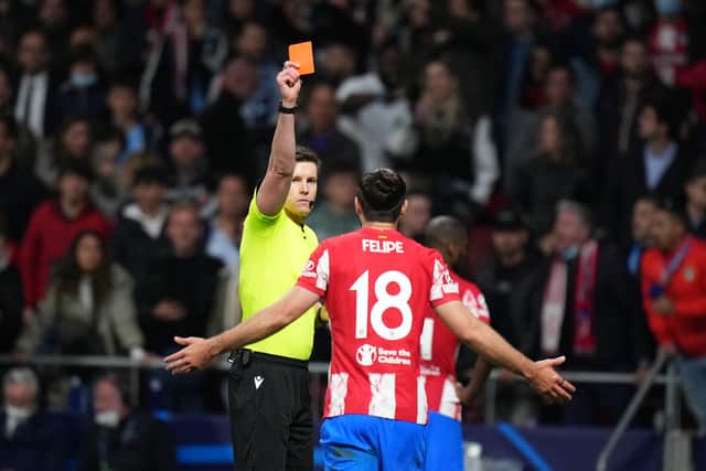 Referee Daniel Siebert gives Felipe of Atletico Madrid a red card