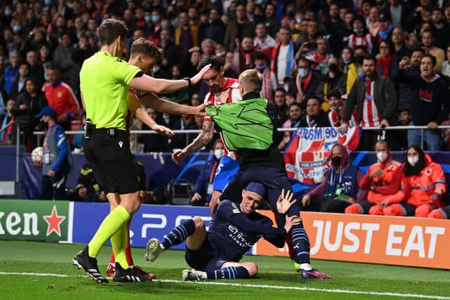 Oleksandr Zinchenko ‘holds off' Stefan Savic of Atletico Madrid as Phil Foden is seen on the floor