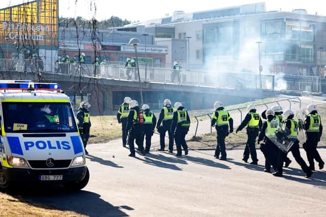 Riot police pass a barricade to enter a shopping centre during rioting in Norrkoping, Sweden on April 17, 2022 (Photo: STEFAN JERREVANG/TT News Agency/AFP via Getty Images)