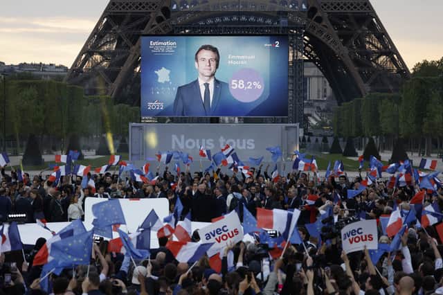Supporters react after the victory of French President and La Republique en Marche (LREM) party candidate for re-election Emmanuel Macron in France's presidential election, at the Champ de Mars, in Paris, on April 24, 2022. (Photo by Ludovic MARIN / AFP) 