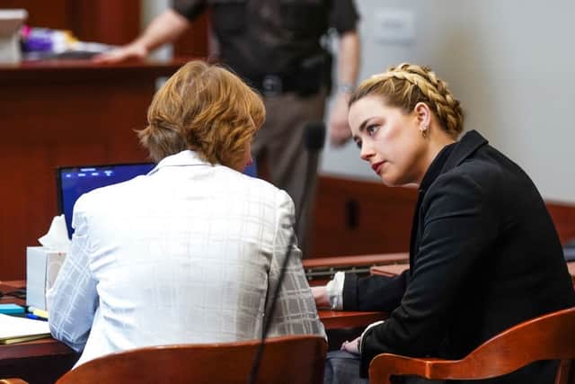 Amber Heard listening to her legal team during the Depp vs Heard defamation trial (Photo by SHAWN THEW/POOL/AFP via Getty Images)