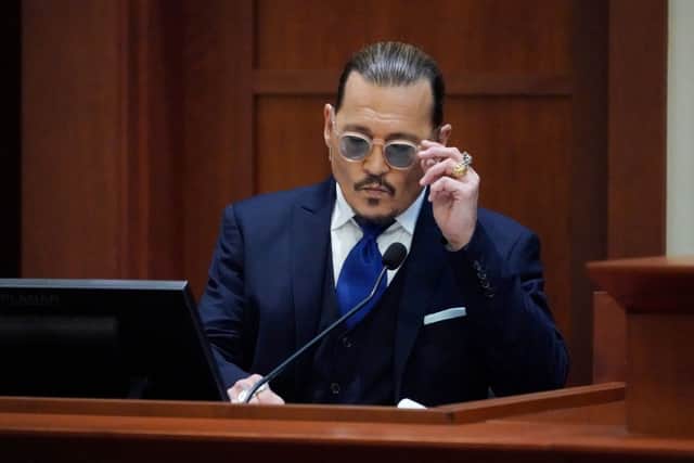 Actor Johnny Depp sits to testify in the courtroom at the Fairfax County Circuit Courthouse in Fairfax, Virginia, April 25, 2022 (Photo by STEVE HELBER/POOL/AFP via Getty Images)