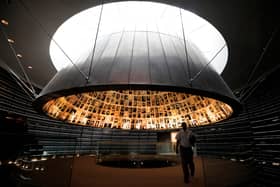 A picture taken on April 20, 2020, shows an employee leaving the Hall of Names, bearing names and pictures of Jewish Holocaust victims, at the Yad Vashem Holocaust memorial museum in Jerusalem
