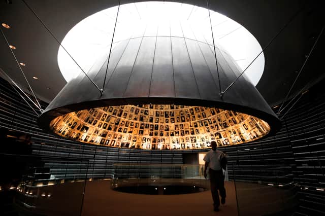 A picture taken on April 20, 2020, shows an employee leaving the Hall of Names, bearing names and pictures of Jewish Holocaust victims, at the Yad Vashem Holocaust memorial museum in Jerusalem