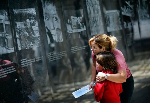  Genevieve Pared hugs her son Jason Pared as they look at photographs on display as they visit the Holocaust Memorial during Yom HaShoah-Holocaust Remembrance Day 