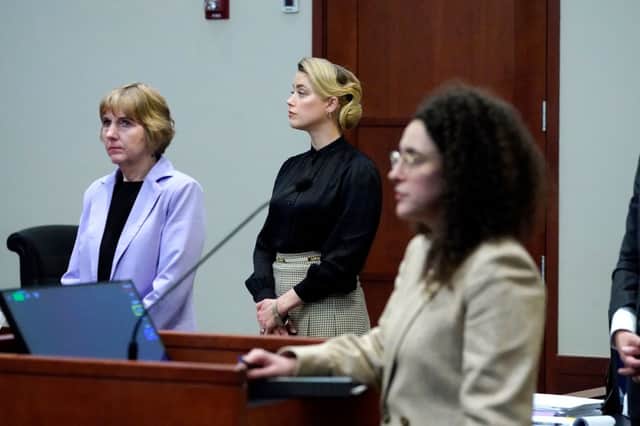 Amber Heard standing as the jury leaves for a lunch break in the courtroom at the Fairfax County Circuit Courthouse (Photo by STEVE HELBER/POOL/AFP via Getty Images)